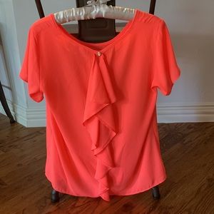 Charming Charlie M neon coral shirt. Ruffle in back.